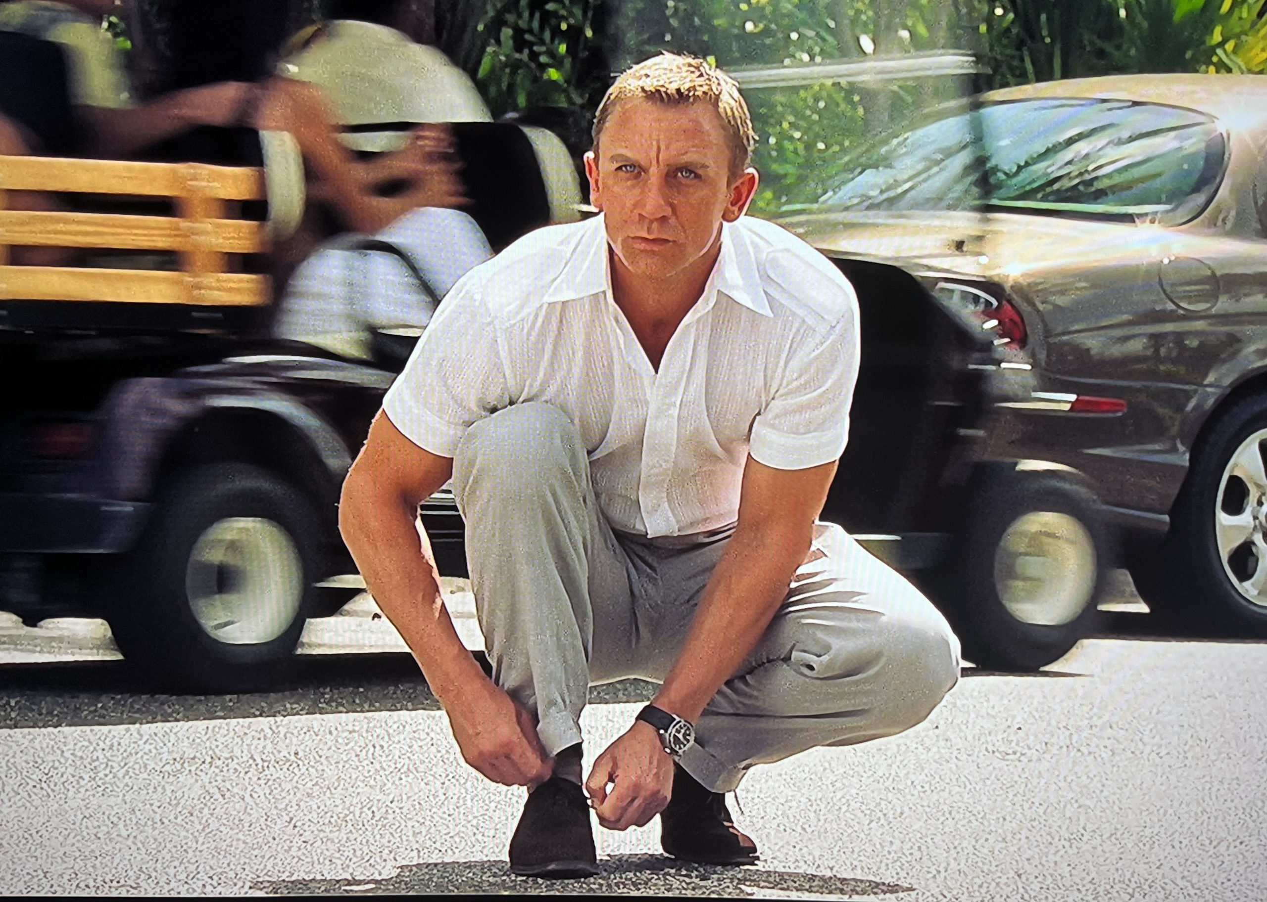 Daniel Craig's Physique looks good in shirt doing up shoe laces