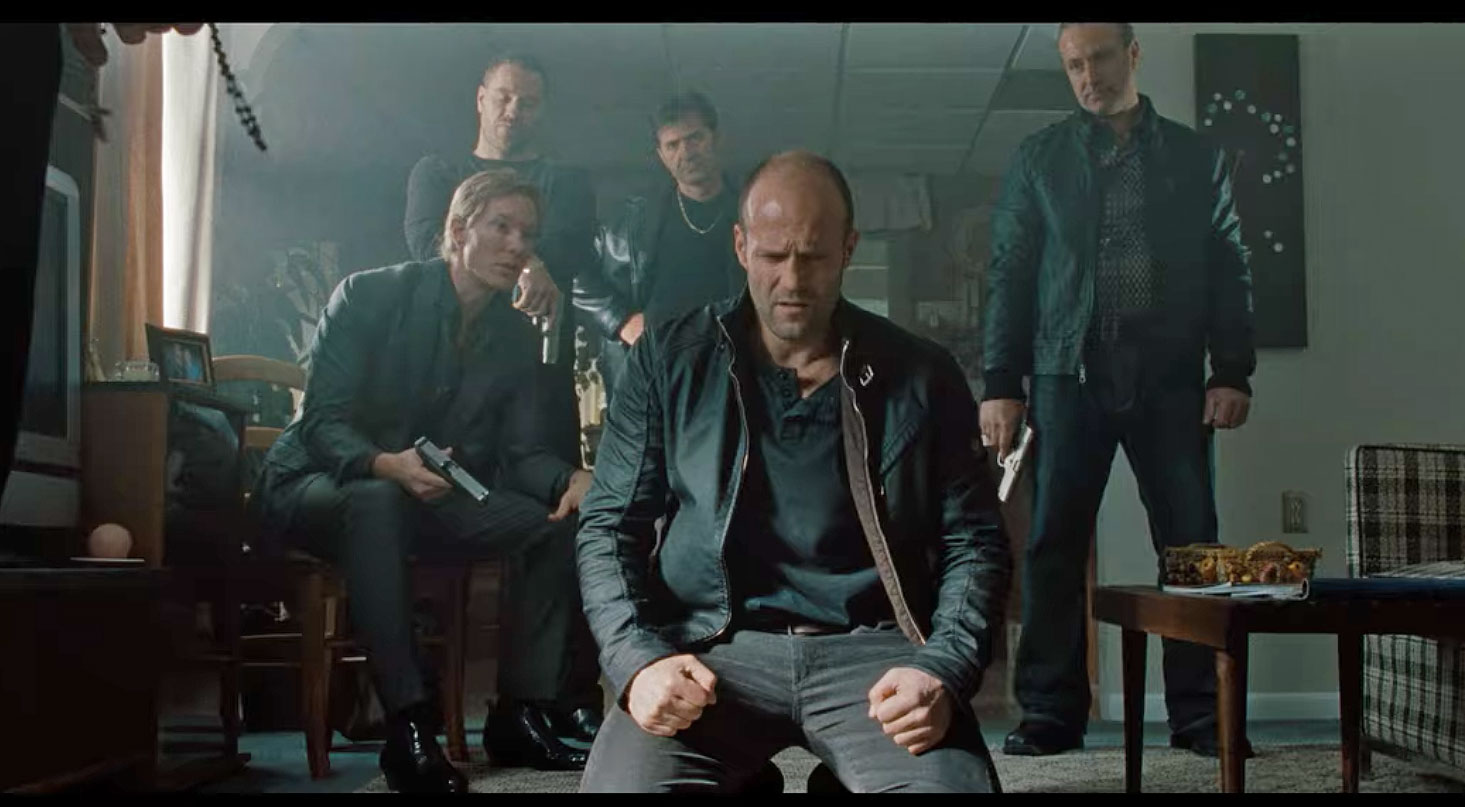 Jason Statham kneeling in a Belstaff Leather jacket