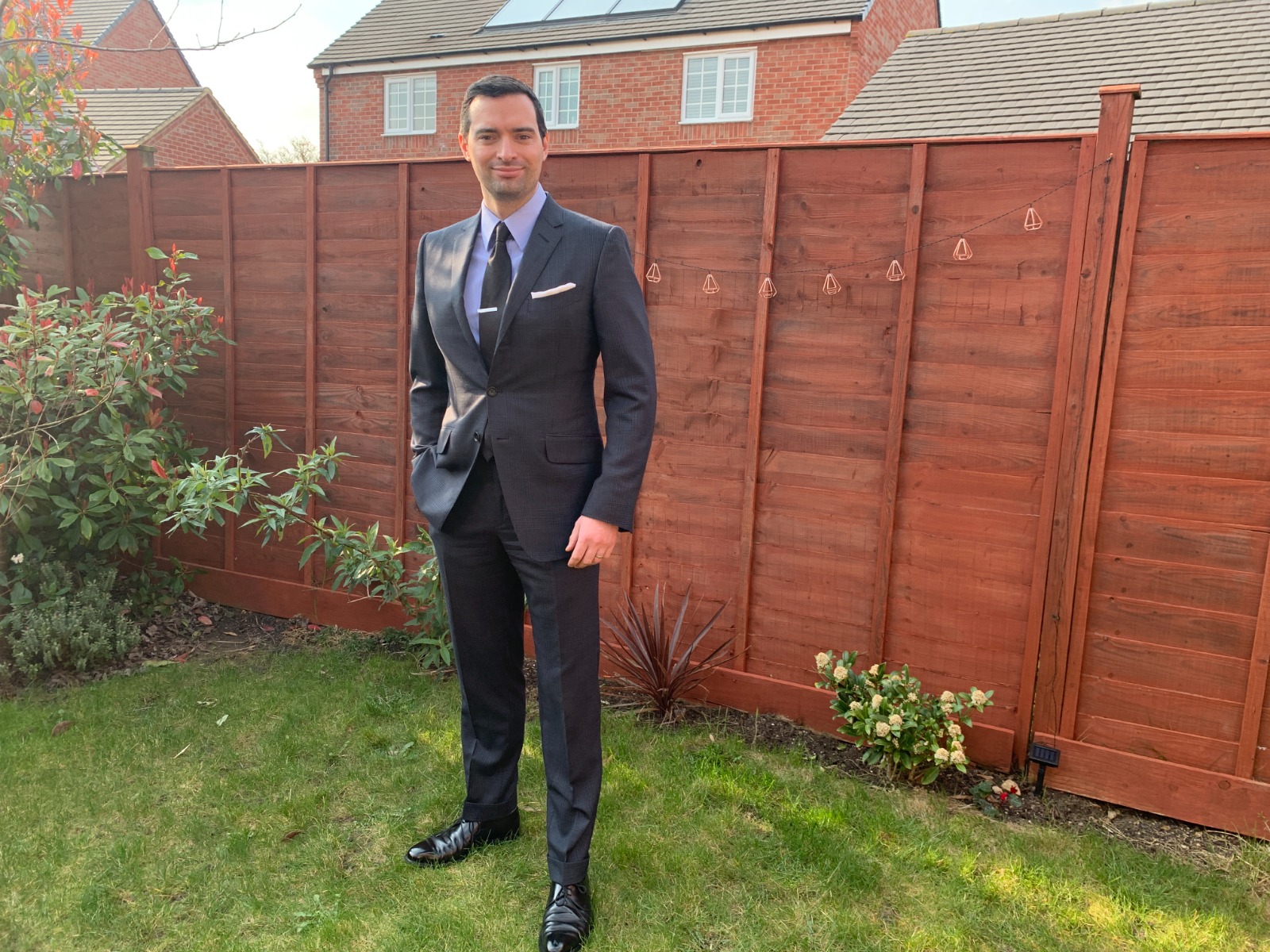 Daniel Gaster wearing a Navy Prince of Wales Tom Ford suit in his garden 
