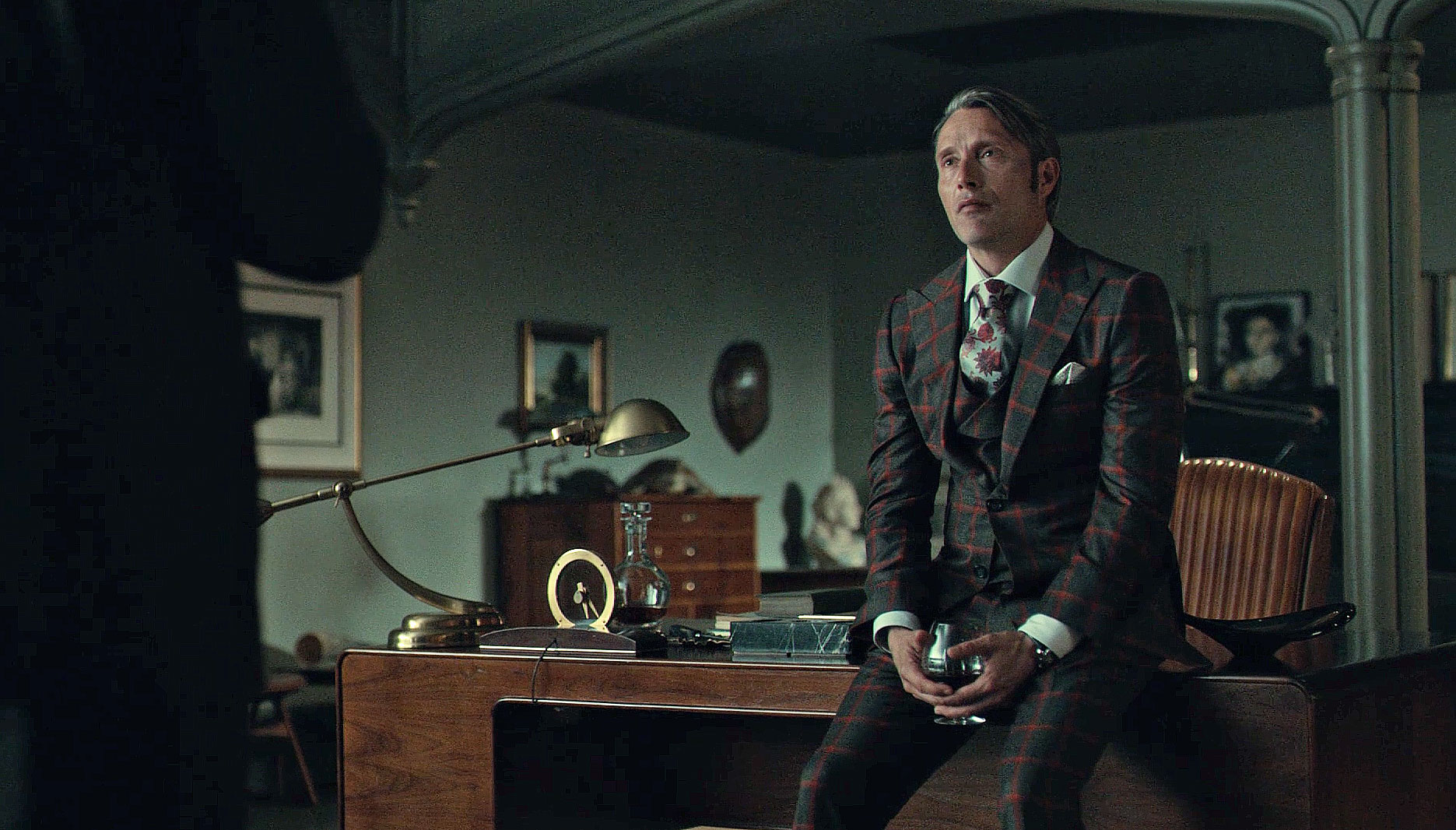 Red Windowpane suit Hannibal sitting on a desk